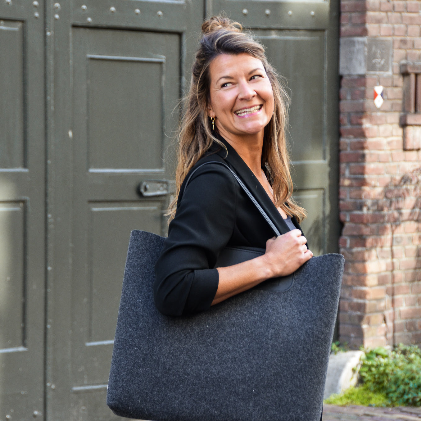 Duurzame shopper Marly handgemaakt van gerecycled wolvilt zwart met vrouw buiten