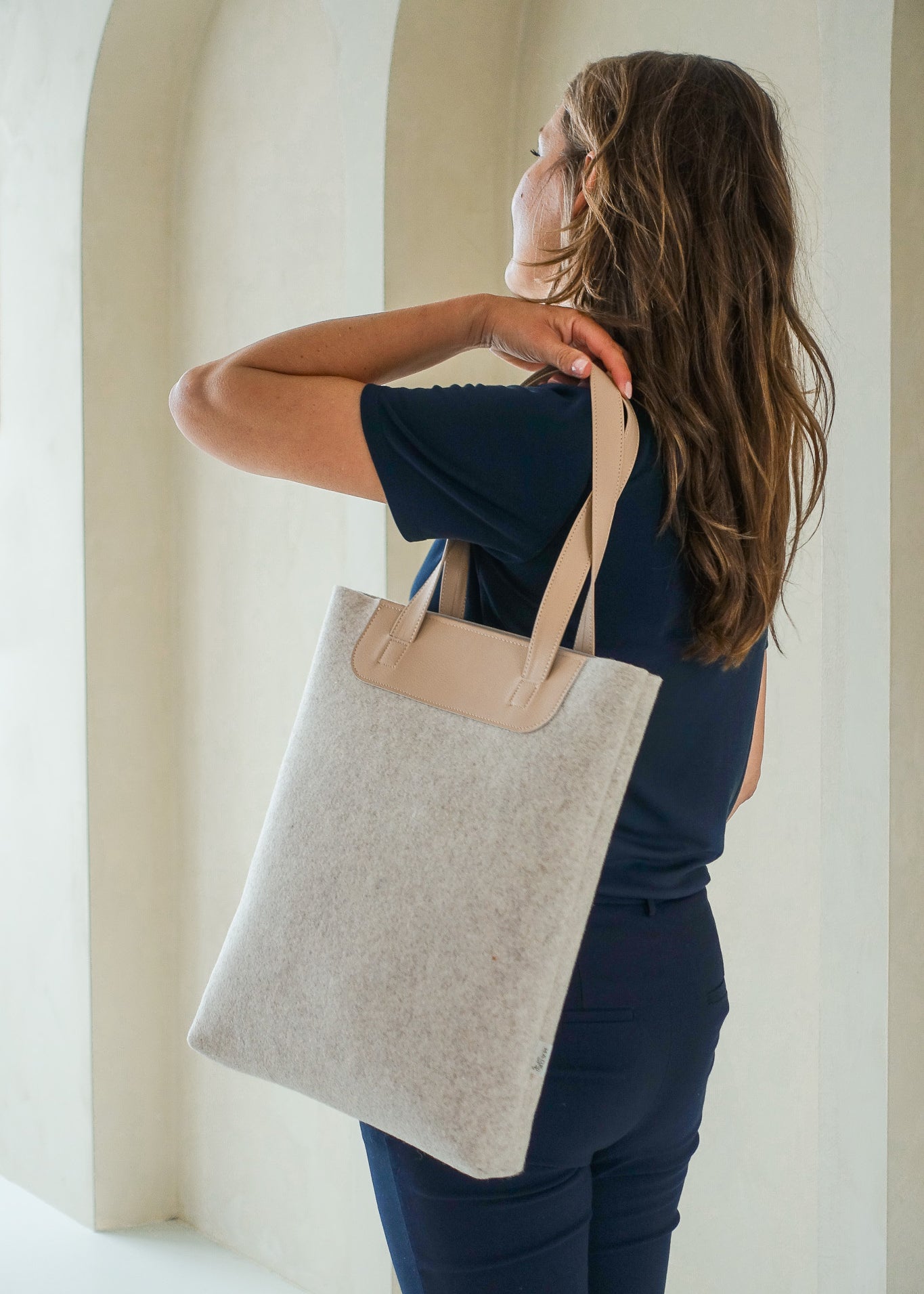 vrouw met duurzame shopper LIN van gerecycled wolvilt  beige met handvatten van vegan appelleer