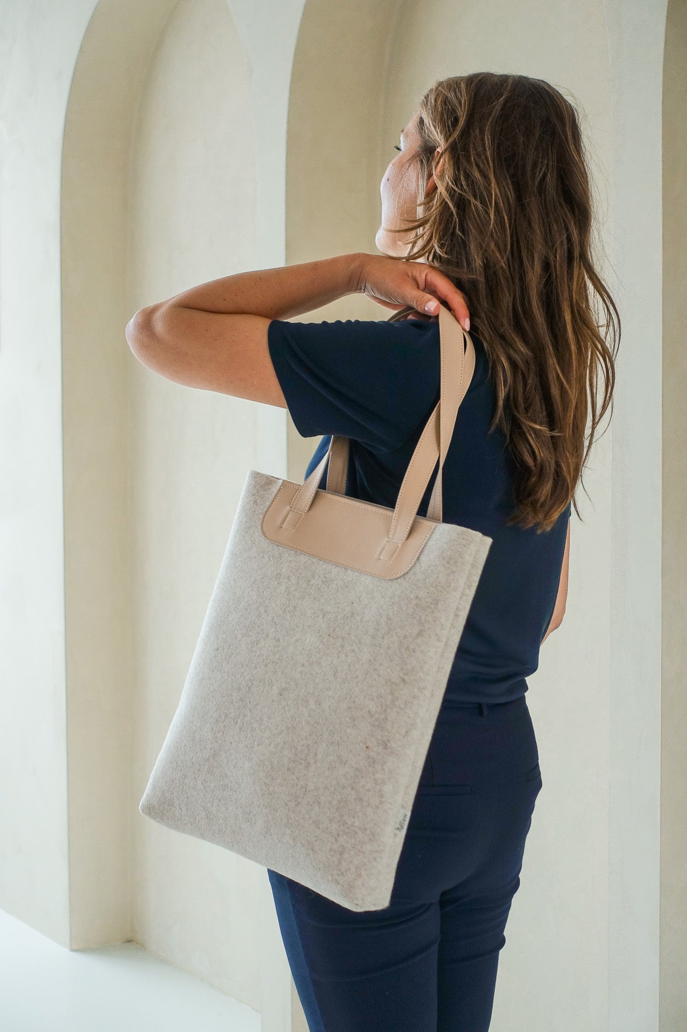 vrouw met duurzame shopper LIN van gerecycled wolvilt  beige met handvatten van vegan appelleer