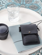 Duurzaam telefoontasje crossbody MOOS van vegan appelleer zwart op tafel 